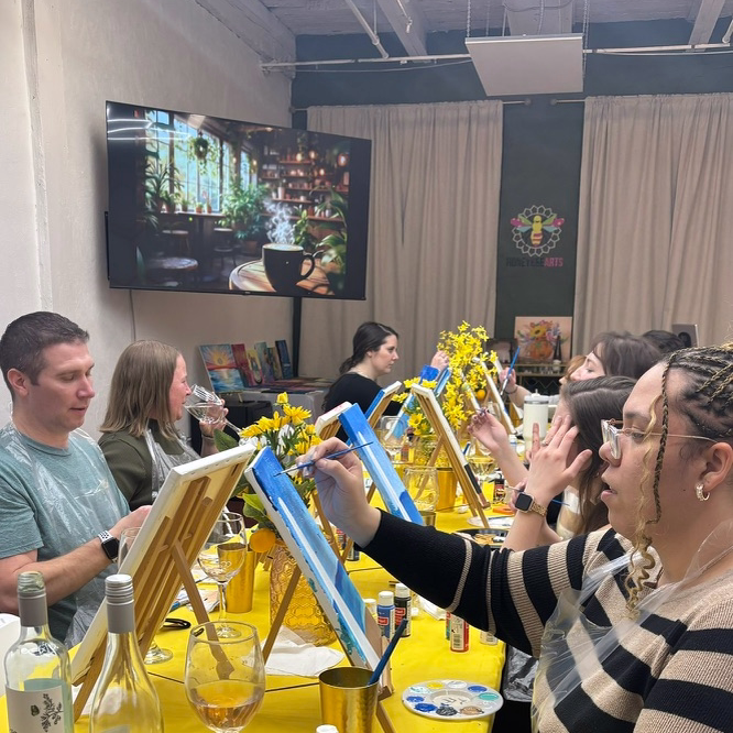 a group of people painting in the honeybee arts paint and sip philadelphia studio